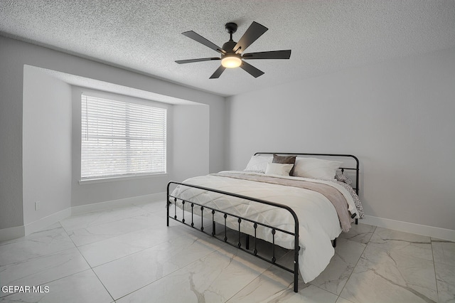 7413 Le Conte Dr, El Paso, TX 79912 - bedroom featuring marble finish floors, baseboards, a textured ceiling, and a ceiling fan