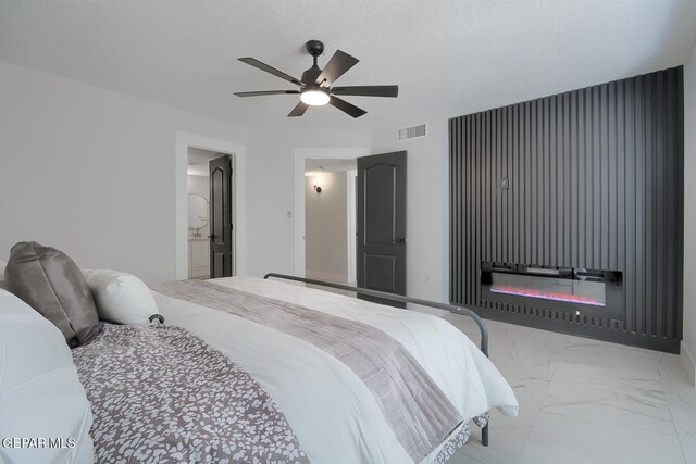 7413 Le Conte Dr, El Paso, TX 79912 - bedroom with marble finish floors, ceiling fan, ensuite bathroom, and a glass covered fireplace