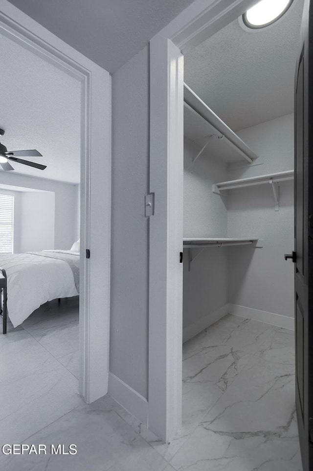 7413 Le Conte Dr, El Paso, TX 79912 - spacious closet with light marble finish flooring and ceiling fan