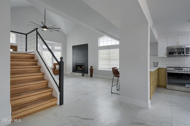 7413 Le Conte Dr, El Paso, TX 79912 - stairs featuring marble finish flooring, baseboards, a fireplace, ceiling fan, and high vaulted ceiling