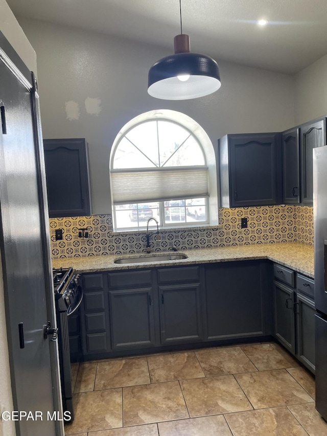 472 Valle Suave Dr, Socorro, TX 79927 - kitchen featuring a sink, black range with gas stovetop, freestanding refrigerator, and tasteful backsplash