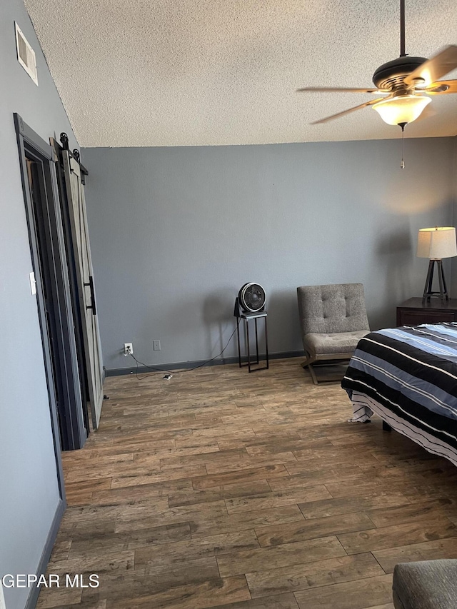 472 Valle Suave Dr, Socorro, TX 79927 - bedroom with a textured ceiling, wood finished floors, a ceiling fan, and baseboards