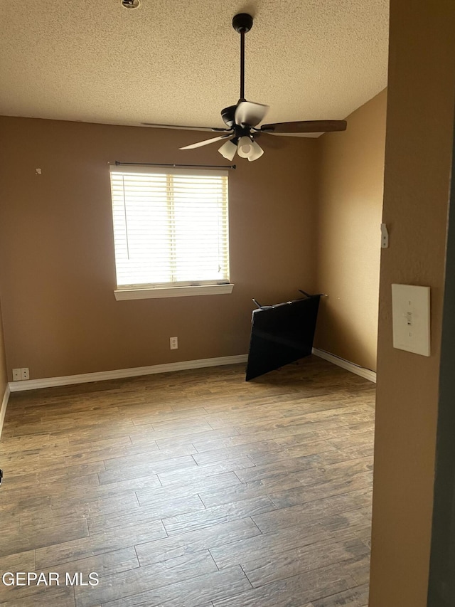 472 Valle Suave Dr, Socorro, TX 79927 - spare room featuring ceiling fan, a textured ceiling, wood finished floors, and baseboards
