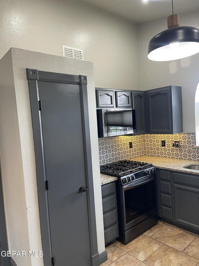 472 Valle Suave Dr, Socorro, TX 79927 - kitchen featuring stainless steel appliances, backsplash, a sink, light stone counters, and a textured wall