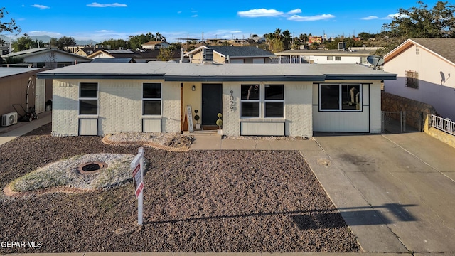 9029 Geranium Dr, El Paso, TX 79907 - view of front of home with brick siding, a fire pit, fence, and a residential view