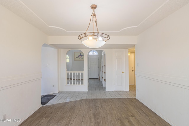 3020 Lake Travis Pl, El Paso, TX 79936 - unfurnished dining area featuring arched walkways, wood finished floors, and baseboards