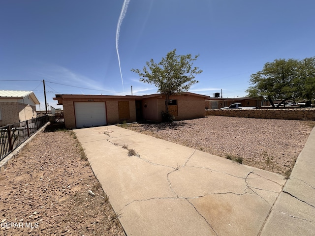 10612 Elsa Pl, El Paso, TX 79924 - view of front facade with concrete driveway, brick siding, fence, and a garage