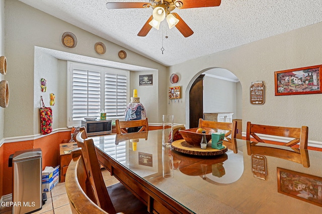 1664 Lou Graham Dr, El Paso, TX 79936 - dining area featuring a ceiling fan, a textured ceiling, arched walkways, lofted ceiling, and tile patterned floors