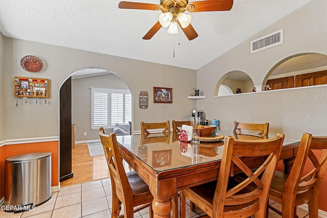 1664 Lou Graham Dr, El Paso, TX 79936 - dining space with a textured ceiling, light tile patterned flooring, a ceiling fan, arched walkways, and vaulted ceiling