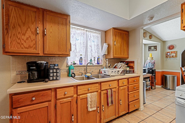 1664 Lou Graham Dr, El Paso, TX 79936 - kitchen with a textured ceiling, a sink, decorative backsplash, light tile patterned flooring, and light countertops