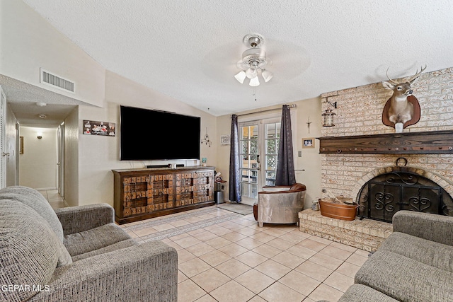 1664 Lou Graham Dr, El Paso, TX 79936 - living area featuring a ceiling fan, light tile patterned floors, a textured ceiling, vaulted ceiling, and a brick fireplace