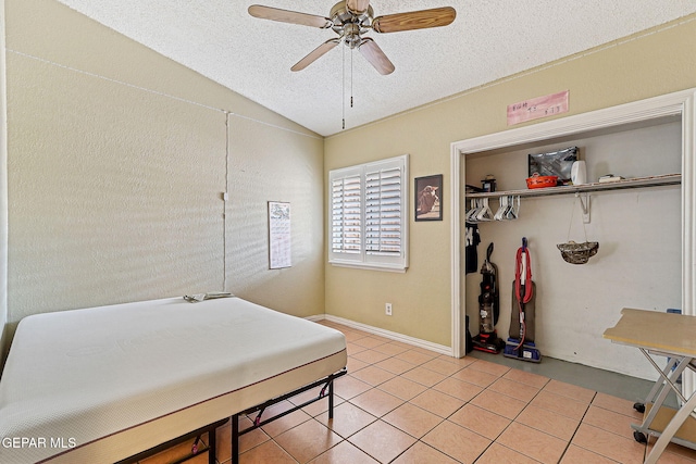 1664 Lou Graham Dr, El Paso, TX 79936 - bedroom with a textured ceiling, light tile patterned flooring, vaulted ceiling, a closet, and ceiling fan