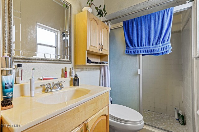 1664 Lou Graham Dr, El Paso, TX 79936 - bathroom featuring toilet, vanity, a shower stall, and a textured wall