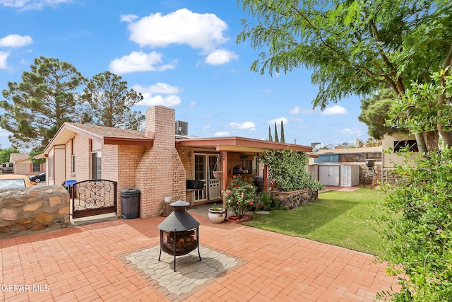 1664 Lou Graham Dr, El Paso, TX 79936 - back of property featuring a patio, brick siding, a chimney, an outdoor fire pit, and a shed