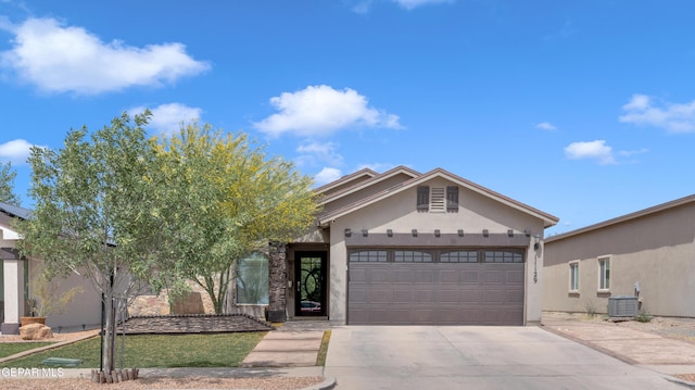 11129 Catherine Slutter Ln, Socorro, TX 79927 - view of front of property with concrete driveway, stucco siding, a garage, and central AC unit