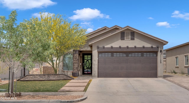 11129 Catherine Slutter Ln, Socorro, TX 79927 - view of front facade with concrete driveway, a garage, and stucco siding