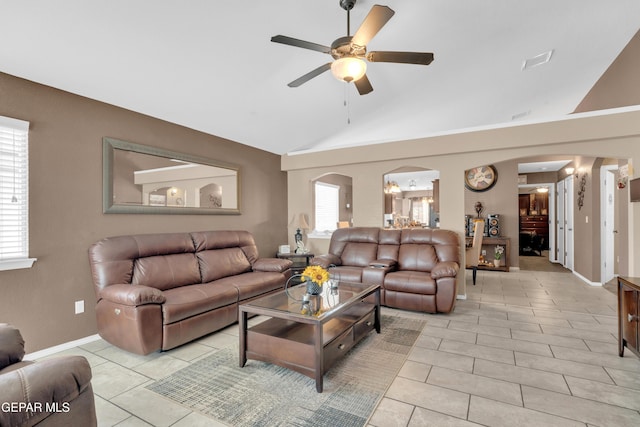 11129 Catherine Slutter Ln, Socorro, TX 79927 - living area with arched walkways, ceiling fan, light tile patterned floors, baseboards, and high vaulted ceiling