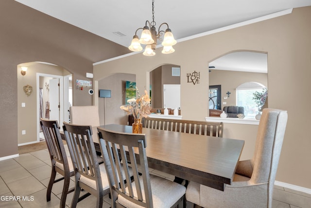 11129 Catherine Slutter Ln, Socorro, TX 79927 - dining space with light tile patterned floors, baseboards, arched walkways, and ornamental molding