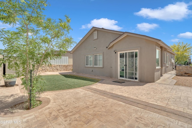 11129 Catherine Slutter Ln, Socorro, TX 79927 - back of house with stucco siding, a patio area, a gate, and fence