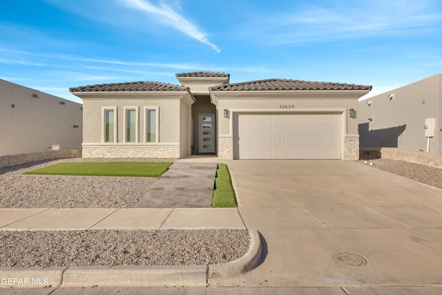 12849 Middlesbrough Ave, Horizon City, TX 79928 - view of front facade with stone siding, stucco siding, a garage, and driveway
