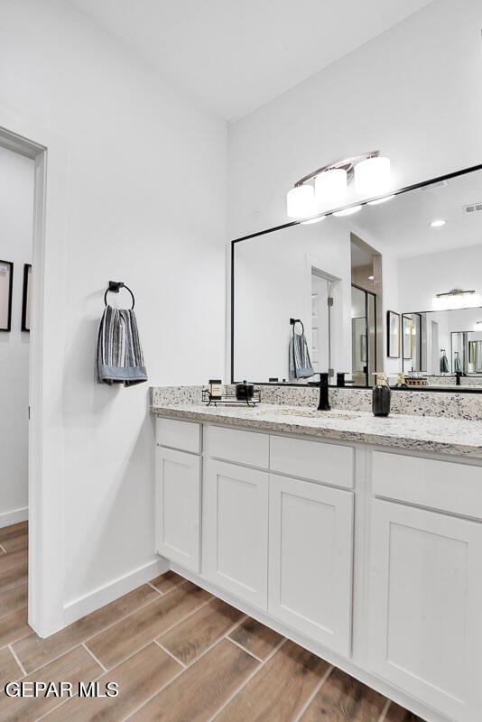 12849 Middlesbrough Ave, Horizon City, TX 79928 - full bath featuring wood finished floors, vanity, and baseboards