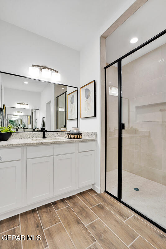 12849 Middlesbrough Ave, Horizon City, TX 79928 - full bathroom featuring a shower stall, wood tiled floors, and vanity