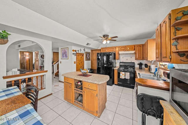 11968 Frances Scobee Dr, El Paso, TX 79936 - kitchen with black appliances, a center island, under cabinet range hood, open shelves, and light countertops