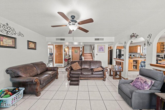 11968 Frances Scobee Dr, El Paso, TX 79936 - living area featuring a ceiling fan, light tile patterned flooring, arched walkways, a textured ceiling, and stairway