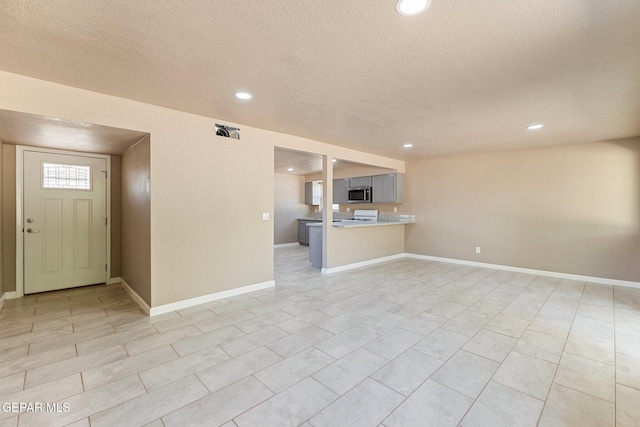 2912 Jarvis Dr, El Paso, TX 79935 - unfurnished living room featuring a textured ceiling, recessed lighting, and baseboards