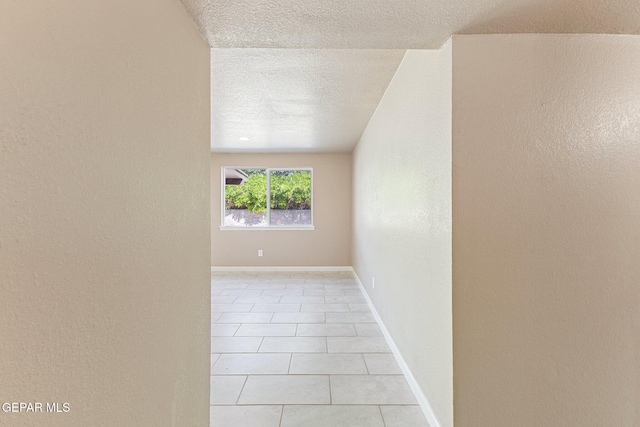 2912 Jarvis Dr, El Paso, TX 79935 - unfurnished room with light tile patterned floors, a textured ceiling, a textured wall, and baseboards