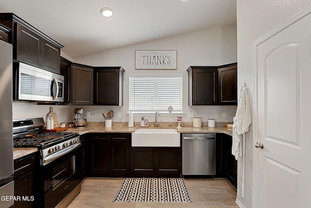 436 Sun Temple Rd, Socorro, TX 79927 - kitchen with stainless steel appliances, a sink, lofted ceiling, light stone counters, and dark brown cabinets