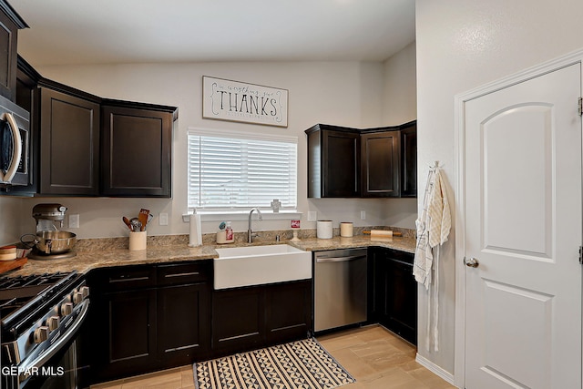 436 Sun Temple Rd, Socorro, TX 79927 - kitchen featuring stainless steel appliances, a sink, light stone counters, lofted ceiling, and dark brown cabinetry