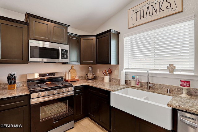 436 Sun Temple Rd, Socorro, TX 79927 - kitchen featuring appliances with stainless steel finishes, a sink, vaulted ceiling, dark brown cabinets, and light stone countertops