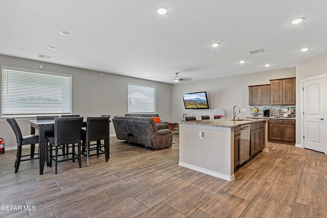 2808 Tierra De Moyo Pl, El Paso, TX 79938 - kitchen featuring dishwasher, a ceiling fan, open floor plan, a kitchen island with sink, and decorative backsplash