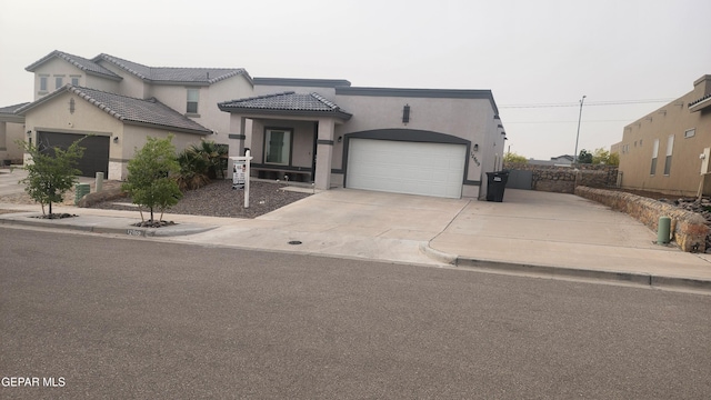 12869 Woolstone Dr, El Paso, TX 79928 - view of front of house featuring concrete driveway, stucco siding, a garage, and a tile roof