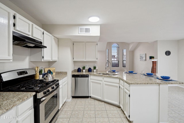 kitchen featuring stainless steel appliances, a sink, a peninsula, light tile patterned floors, and under cabinet range hood