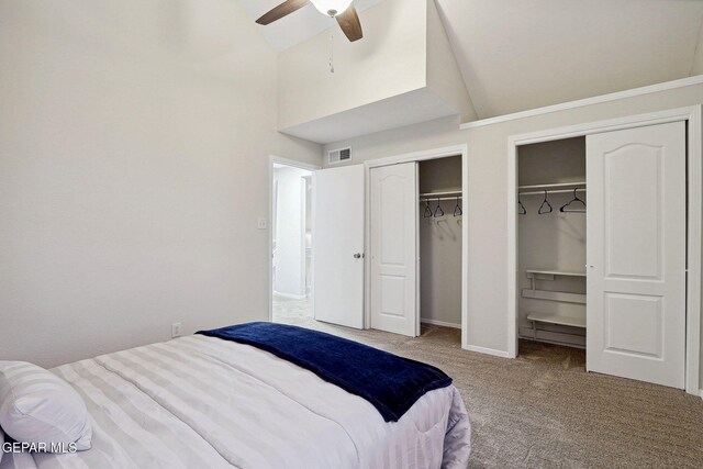 bedroom with two closets, carpet floors, and ceiling fan