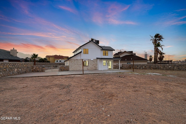 rear view of house featuring a patio area, fence, and stucco siding