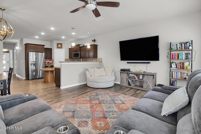 living area featuring ceiling fan, a chandelier, recessed lighting, wood finished floors, and baseboards