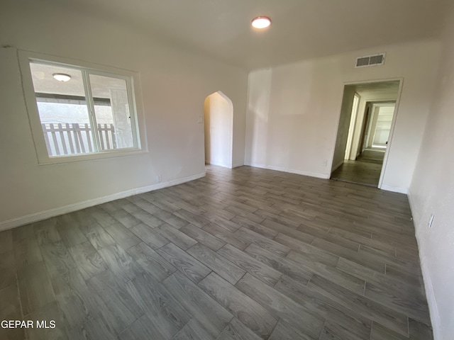 2805 Grant Ave, El Paso, TX 79930 - unfurnished room featuring arched walkways, dark wood-style flooring, and baseboards