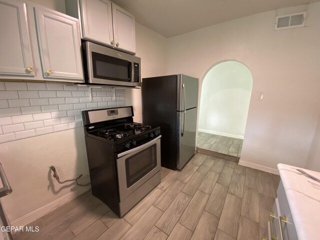 2805 Grant Ave, El Paso, TX 79930 - kitchen featuring stainless steel appliances, light wood-style flooring, baseboards, and decorative backsplash