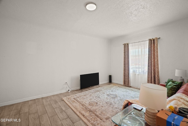 2805 Grant Ave, El Paso, TX 79930 - living room featuring wood finished floors, a textured ceiling, and baseboards