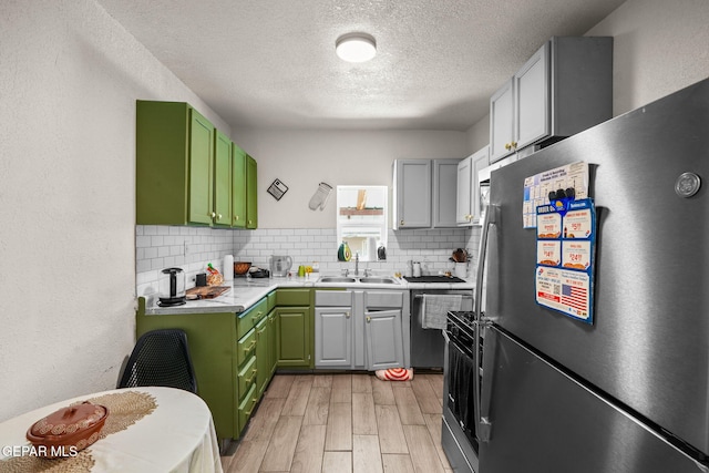 2805 Grant Ave, El Paso, TX 79930 - kitchen with freestanding refrigerator, a sink, green cabinetry, a textured ceiling, and light wood-style flooring