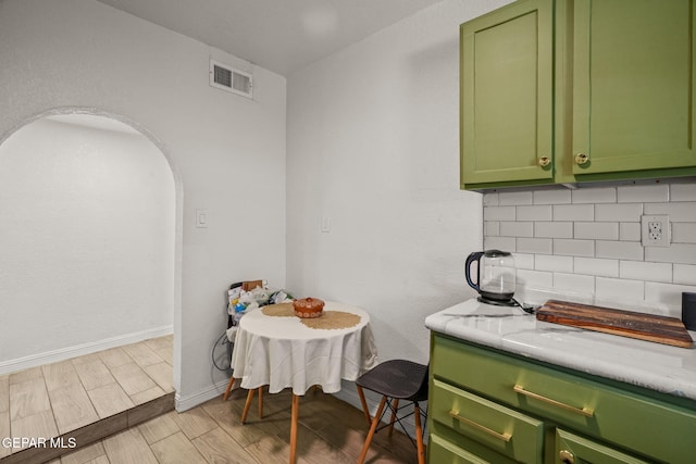 2805 Grant Ave, El Paso, TX 79930 - kitchen with green cabinets, backsplash, light wood-type flooring, light countertops, and baseboards