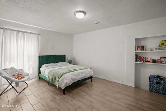 2805 Grant Ave, El Paso, TX 79930 - bedroom featuring wood tiled floors, a textured ceiling, and baseboards