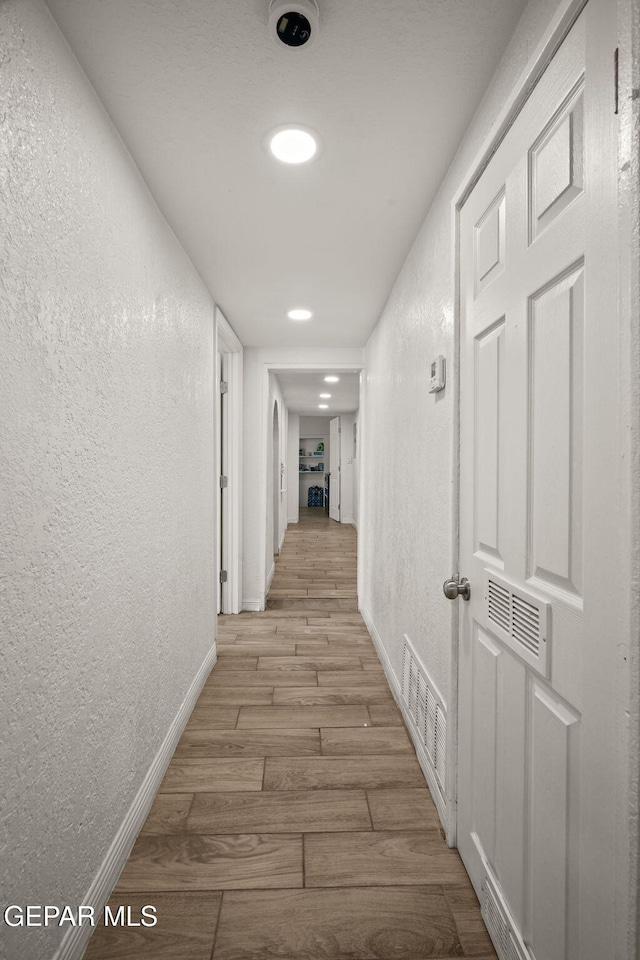 2805 Grant Ave, El Paso, TX 79930 - corridor featuring a textured wall, baseboards, light wood-style flooring, and recessed lighting