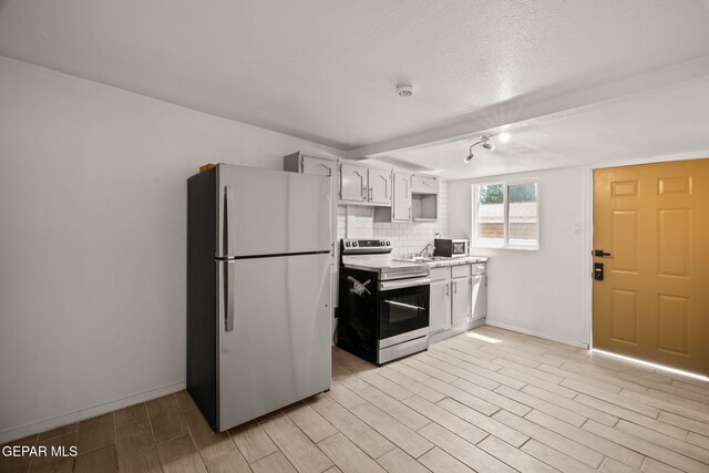 2805 Grant Ave, El Paso, TX 79930 - kitchen featuring appliances with stainless steel finishes, light countertops, light wood-type flooring, baseboards, and tasteful backsplash