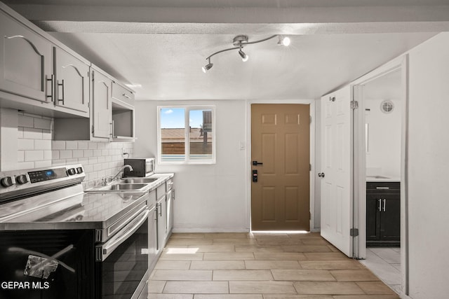 2805 Grant Ave, El Paso, TX 79930 - kitchen with stainless steel electric stove, a sink, decorative backsplash, wood finish floors, and light countertops
