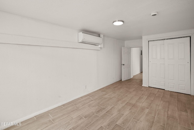2805 Grant Ave, El Paso, TX 79930 - finished basement with a wall unit AC, light wood finished floors, and baseboards