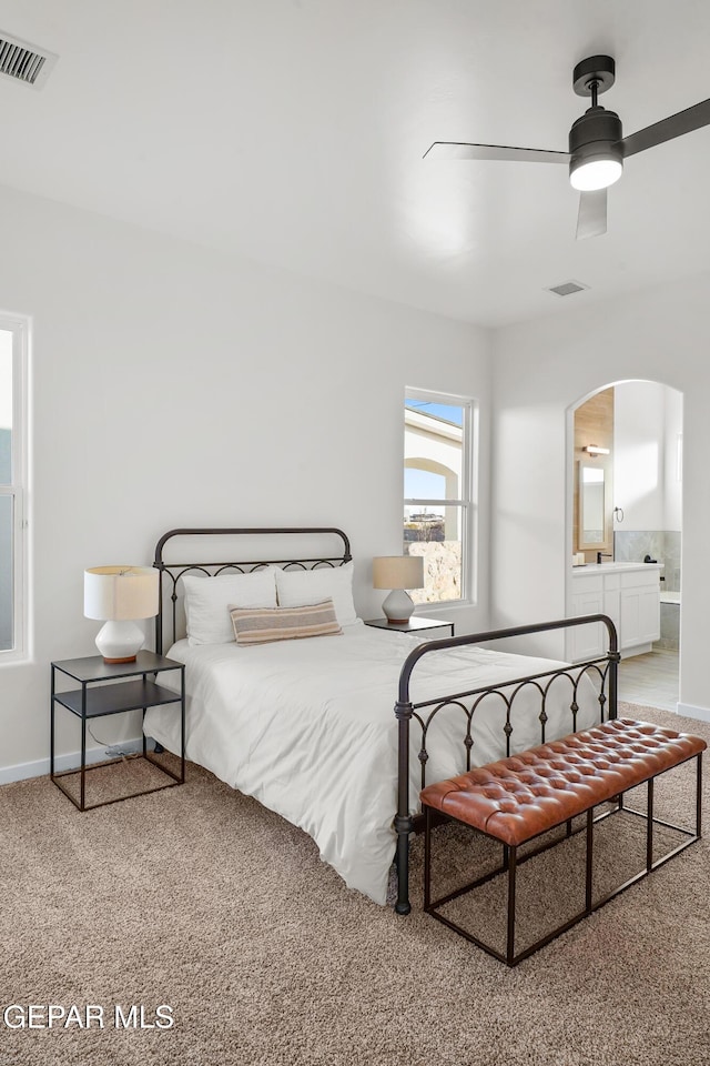 3829 Aspire Pl, El Paso, TX 79938 - bedroom with arched walkways, light carpet, baseboards, and connected bathroom